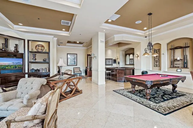 a living room with furniture pool table and a rug