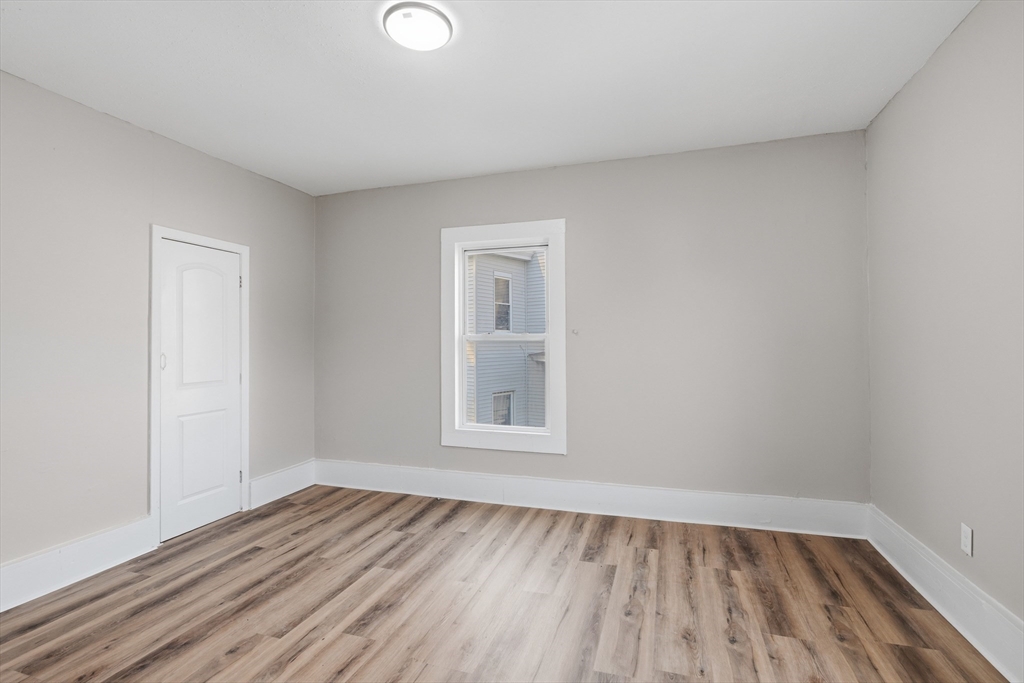 834 Worthington Street, Unit 2 Springfield, MA 01105 - Photo 13 of 20 a view of an empty room with wooden floor and a window