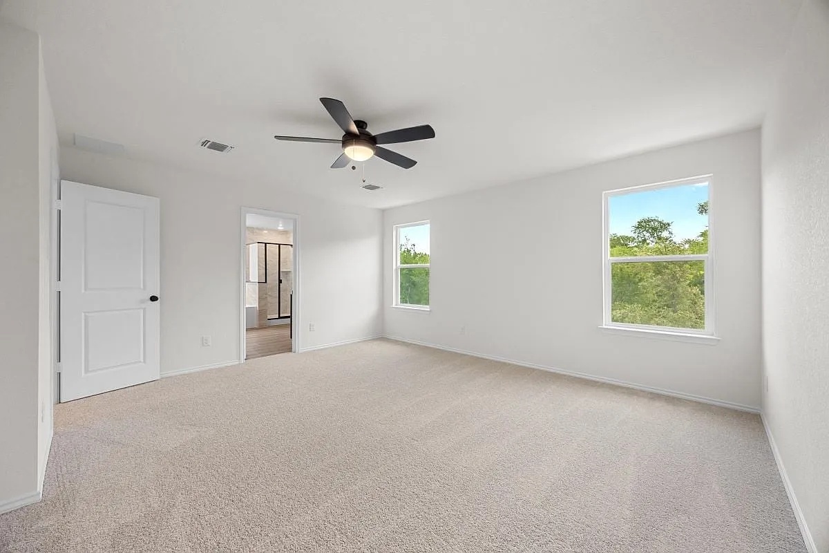 612 St Cindy's Way Pflugerville, TX 78660 - Photo 2 of 6 A spacious, naturally illuminated primary bedroom offers tranquil views and an adjoining bathroom.