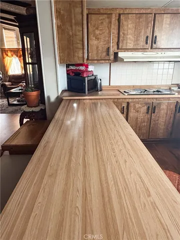 a kitchen with a sink a stove and a wooden floor