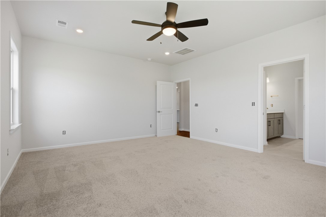 552 Hydrangea Street, Unit LOT 66 Seneca, SC 29678 - Photo 15 of 31 A spacious primary bedroom features soft carpet and an en-suite bathroom access.