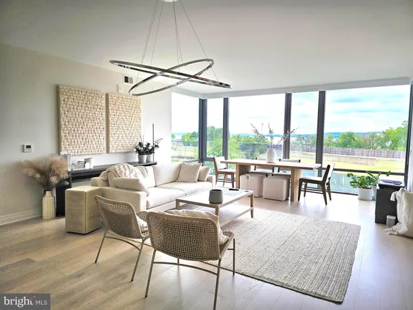 a living room with furniture a flat screen tv and a large window