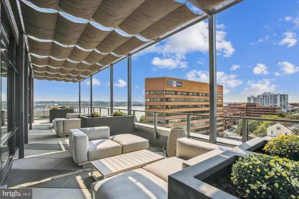 a balcony with furniture and view of city