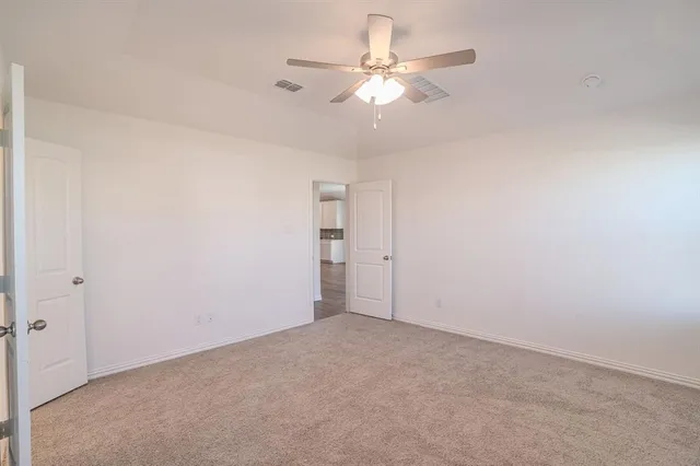an empty room with a chandelier fan