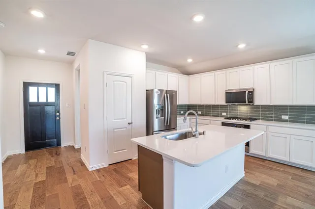 a kitchen with a sink stove and cabinets