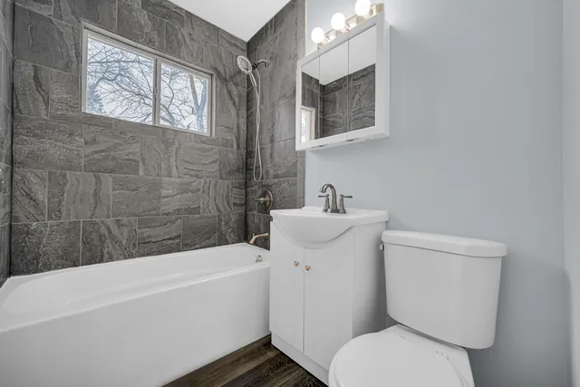 a white toilet sitting next to a bathtub