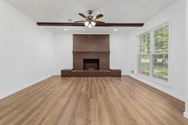 wooden floor fireplace and windows in an empty room