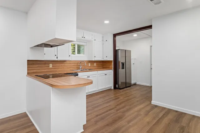 a kitchen with stainless steel appliances granite countertop a sink and a refrigerator