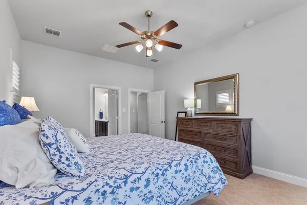 a bedroom with a bed couch and windows