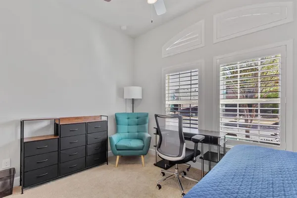 a bedroom with a bed a chair and a chandelier