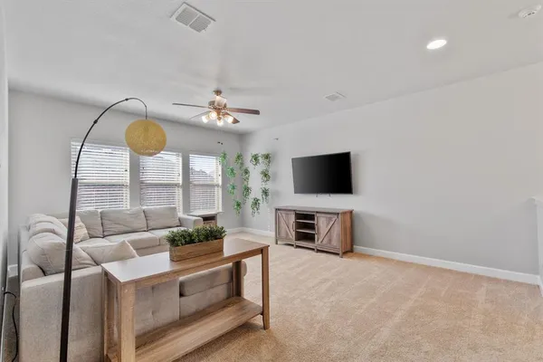 a living room with furniture and a ceiling fan