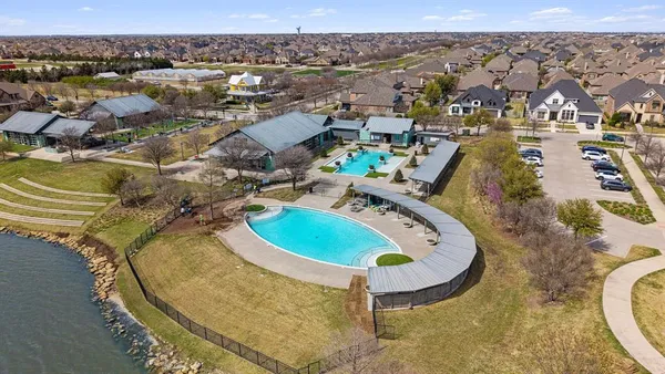an aerial view of residential houses with outdoor space and ocean view