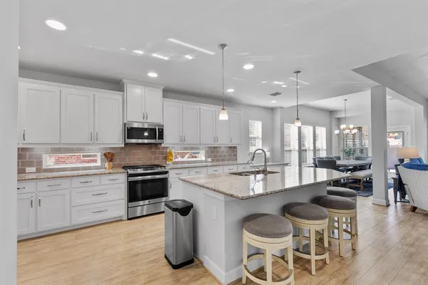 a kitchen with kitchen island granite countertop lots of counter top space and stainless steel appliances
