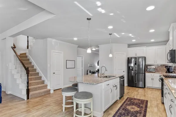 a kitchen with granite countertop living room and chandelier