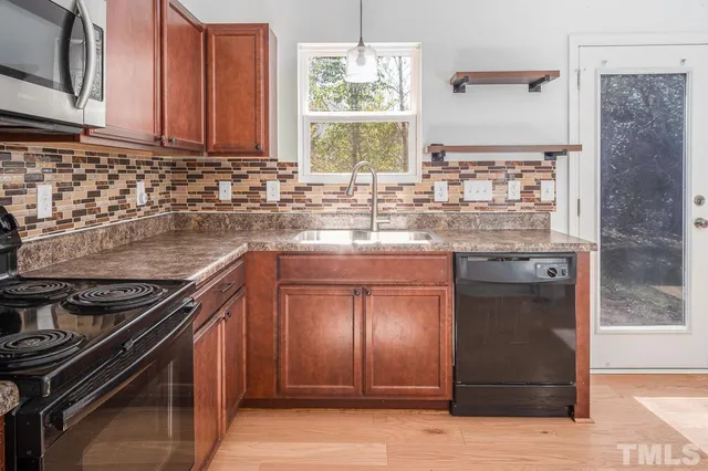 a kitchen with granite countertop a stove and cabinets