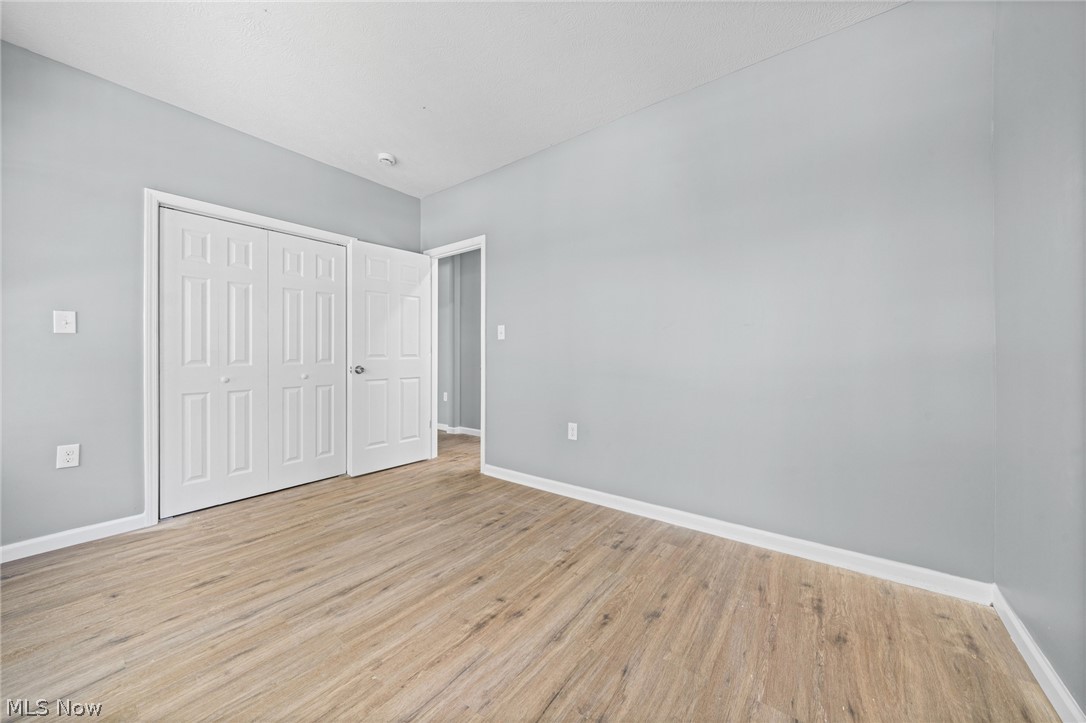 3925 Riverside Avenue Cleveland, OH 44109 - Photo 15 of 48 Spacious room featuring wood-finish flooring, light grey walls, and white baseboards