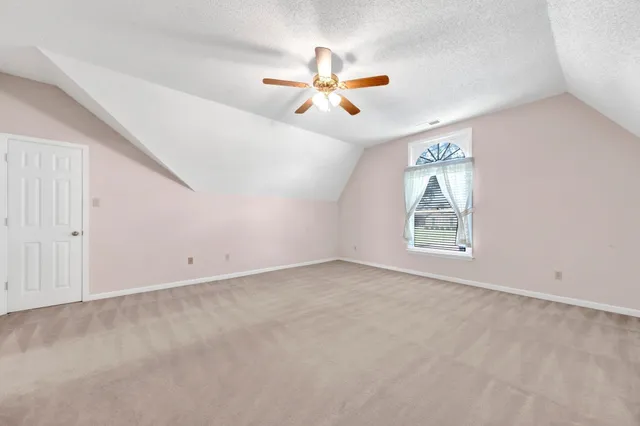 an empty room with closet and a chandelier fan
