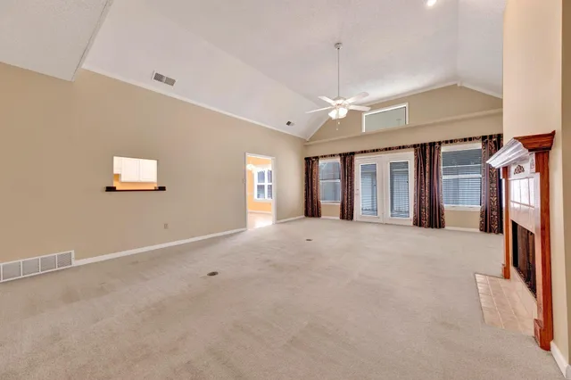 an empty room with fireplace and fan