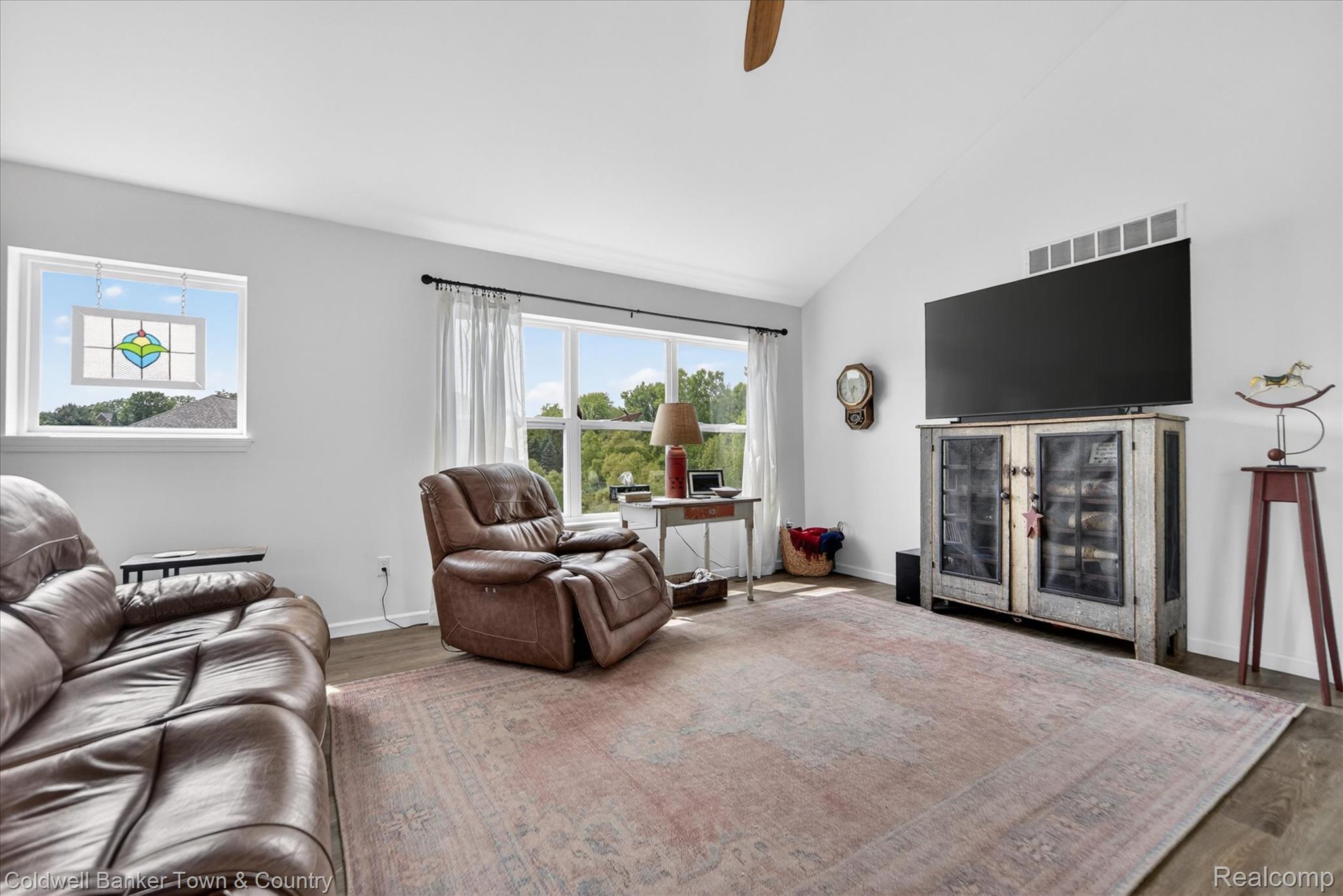 918 Gray Fox Court Howell, MI 48843 - Photo 52 of 84 Spacious living area featuring a vaulted ceiling, wood-finish flooring, and large windows