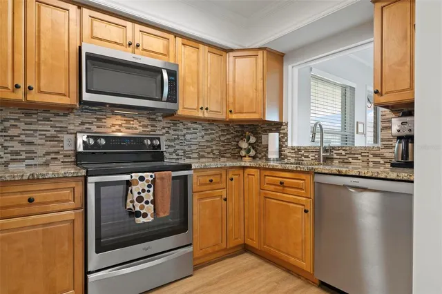 a kitchen with stainless steel appliances granite countertop a stove microwave and cabinets