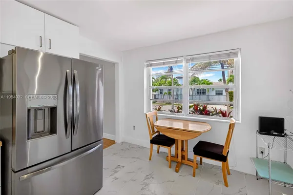 a kitchen with a refrigerator a table and chairs