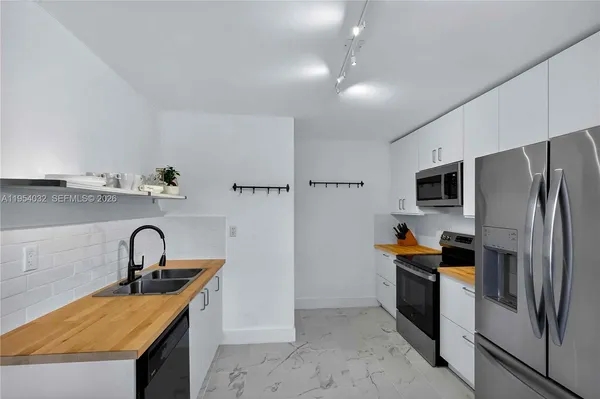 a kitchen with stainless steel appliances granite countertop a sink a stove and a refrigerator