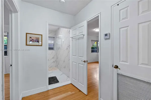 a view of a hallway with wooden floor and closet
