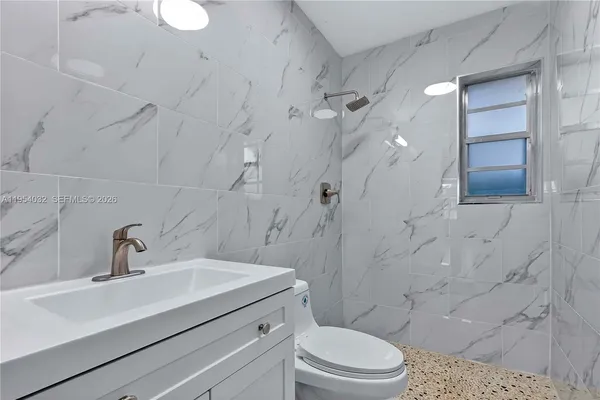 a bathroom with a sink a toilet and shower