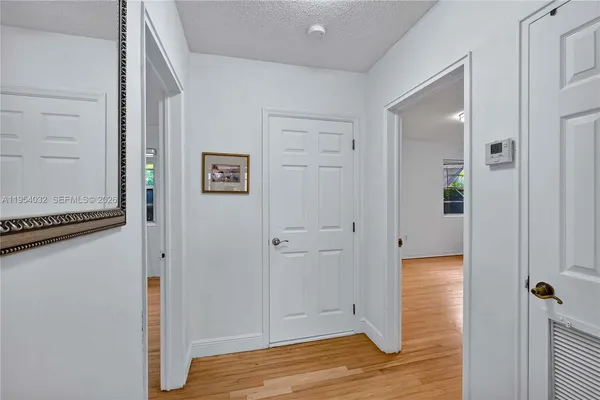 a view of a hallway with wooden floor and closet area
