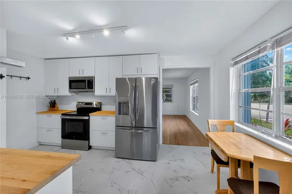 a kitchen with kitchen island a refrigerator stove and microwave