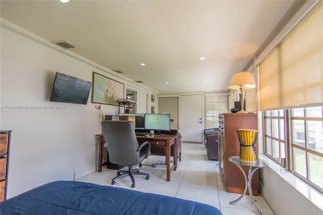 a view of a workspace with furniture and a window