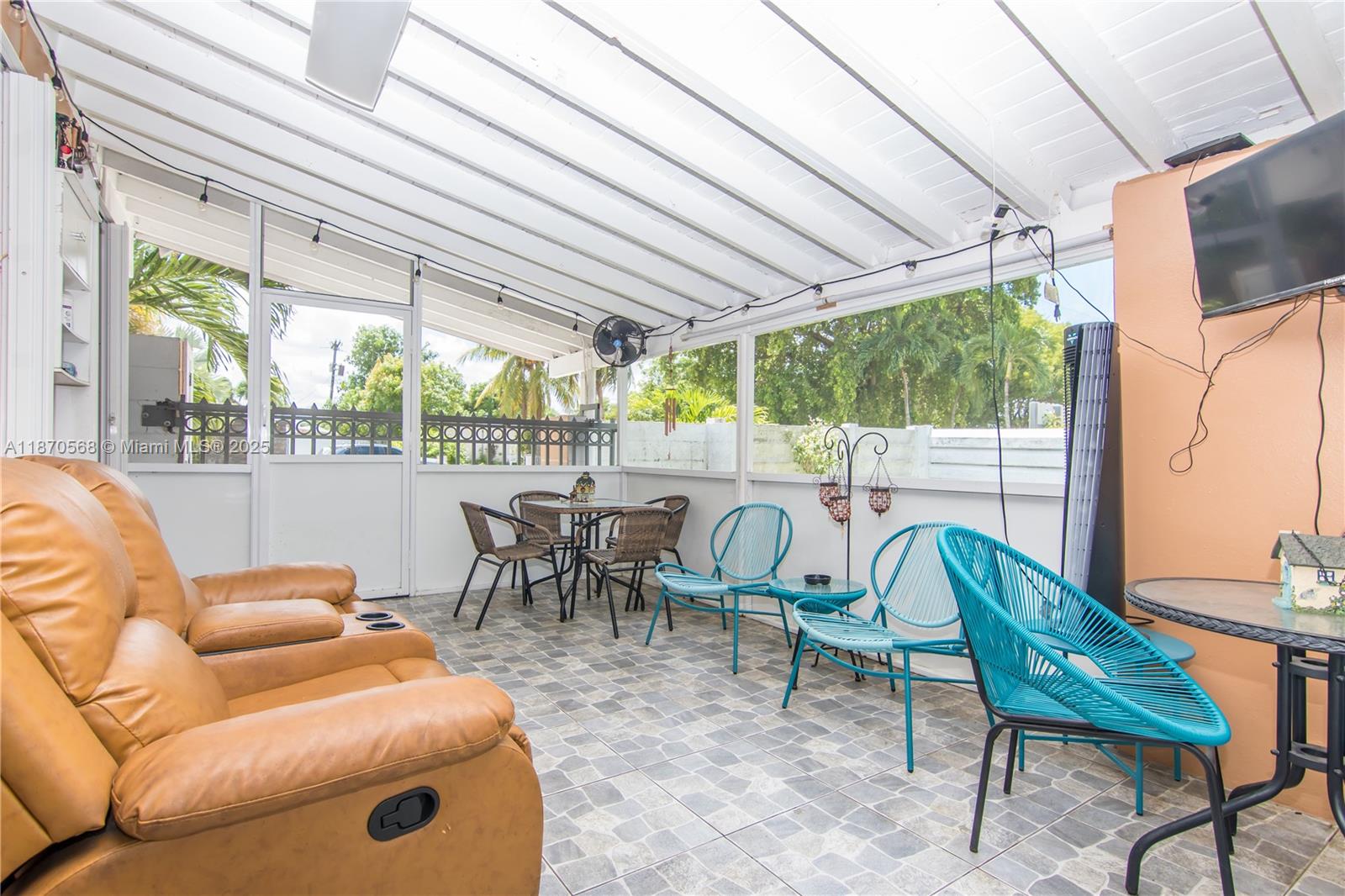 943 West 64th Place Hialeah, FL 33012 - Photo 27 of 32 a view of a patio with table and chairs potted plants and floor to ceiling window
