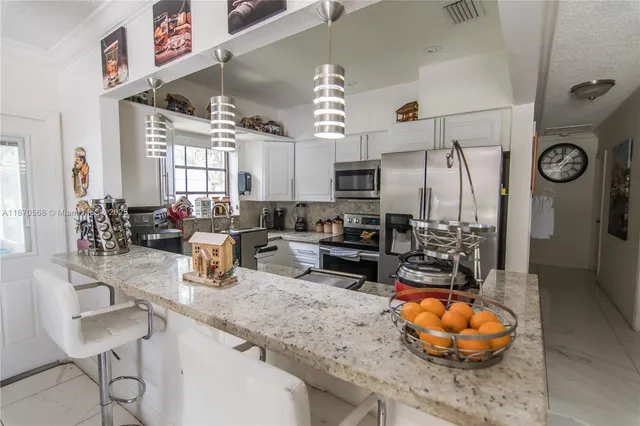 a kitchen with stainless steel appliances granite countertop a sink a stove and a wooden floors