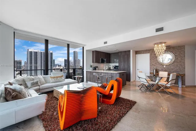 a living room with furniture kitchen view and large windows