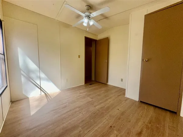 a view of a big room with wooden floor and a ceiling fan