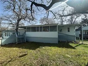 a view of a house with a yard and a large tree