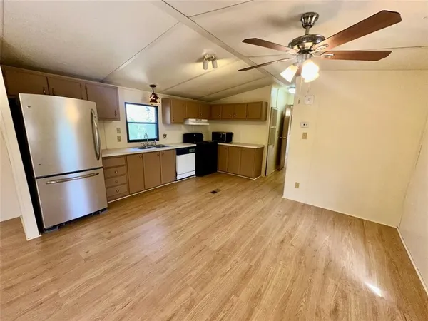 a kitchen with stainless steel appliances a refrigerator and a chandelier