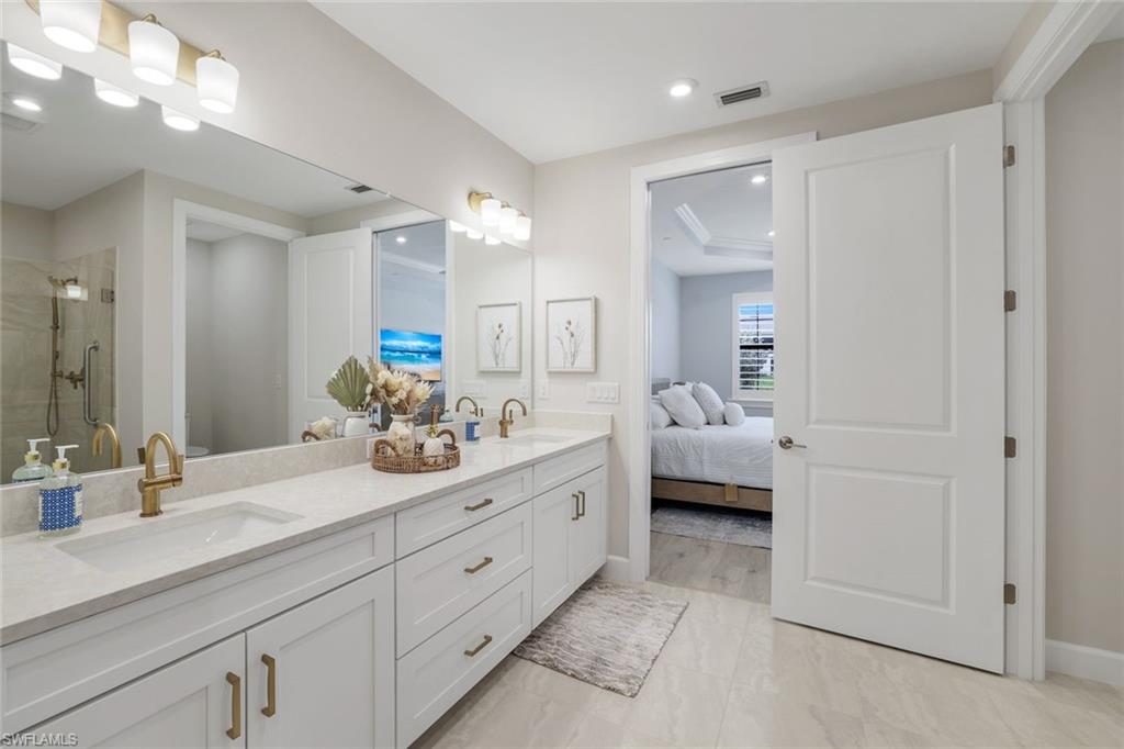 15336 Lucerna Street, Unit 104 Naples, FL 34114 - Photo 11 of 17 a en suite bathroom with double sink and a mirror