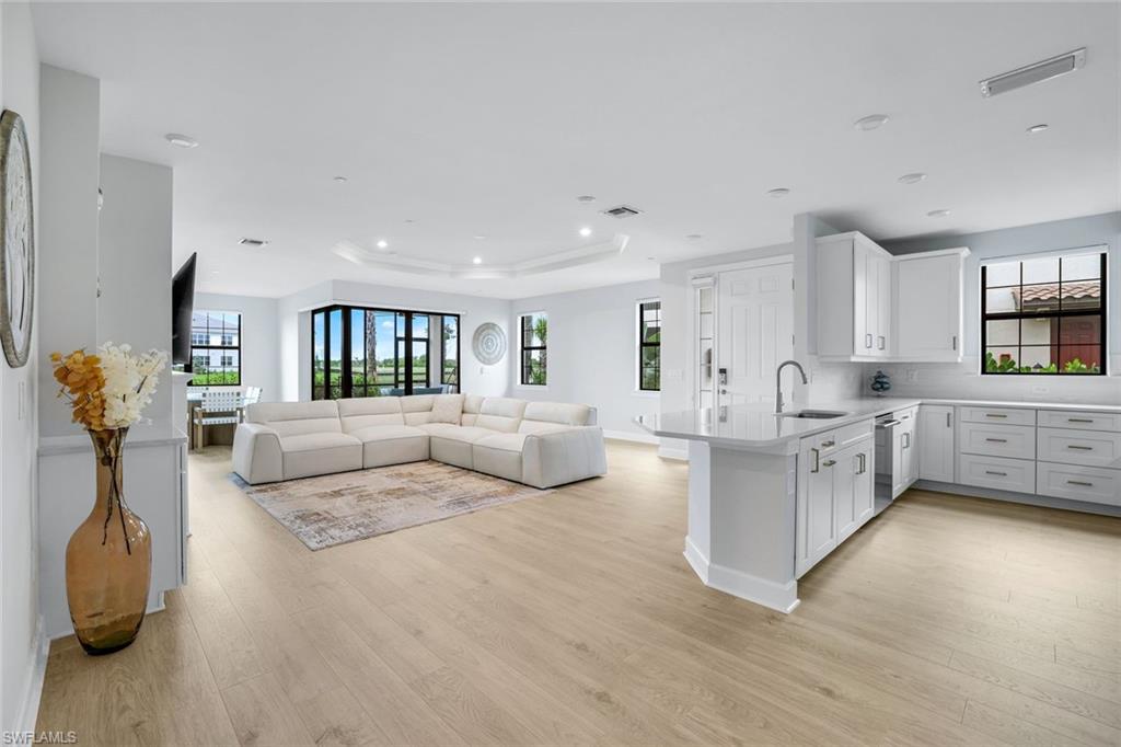 15336 Lucerna Street, Unit 104 Naples, FL 34114 - Photo 2 of 17 a living room with furniture and a wooden floor