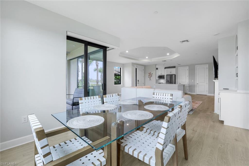 15336 Lucerna Street, Unit 104 Naples, FL 34114 - Photo 7 of 17 a view of a dining room with furniture and wooden floor