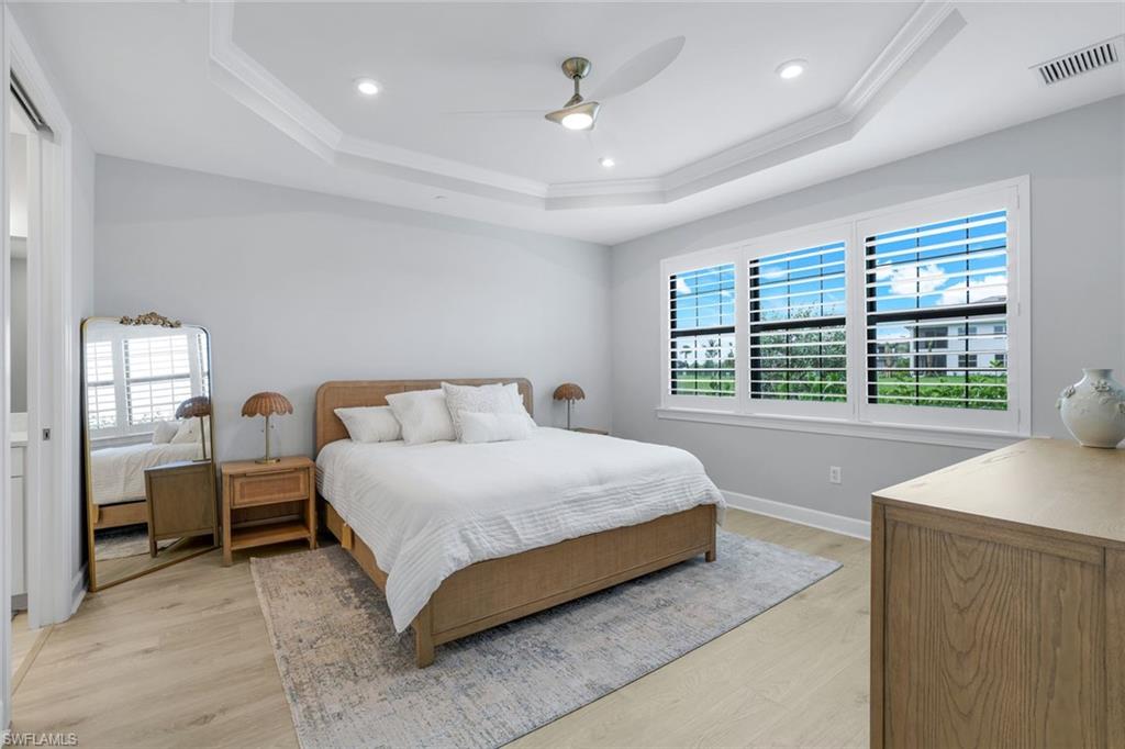 15336 Lucerna Street, Unit 104 Naples, FL 34114 - Photo 8 of 17 a spacious bedroom with a bed and a table in it