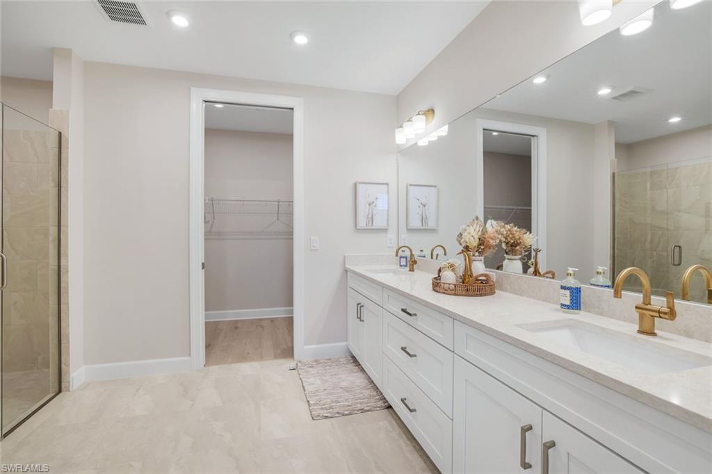 15336 Lucerna Street, Unit 104 Naples, FL 34114 - Photo 10 of 17 a bathroom with a double vanity sink mirror and shower