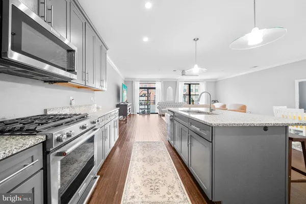 a kitchen with kitchen island granite countertop wooden floors and stainless steel appliances