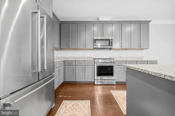 a kitchen with granite countertop kitchen island white cabinets and white appliances