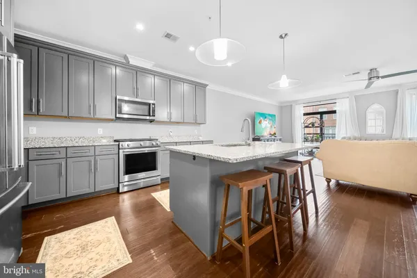 a kitchen with kitchen island a sink stainless steel appliances and white cabinets