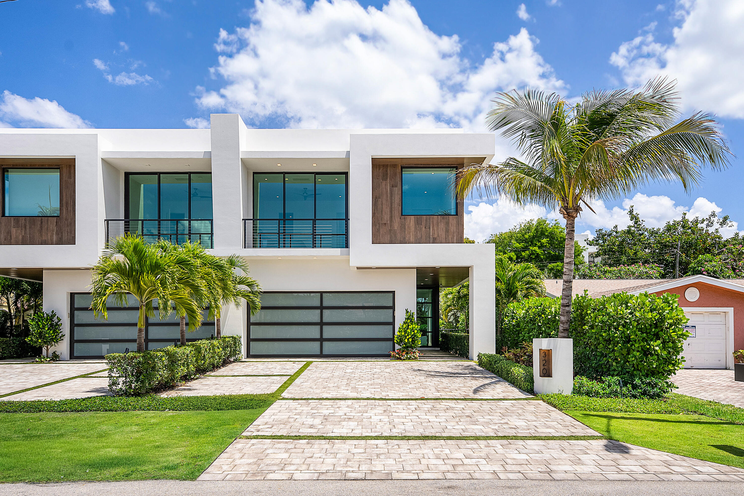 320 Northeast Wavecrest Way Boca Raton, FL 33432 - Photo 1 of 65 a front view of a house with a garden
