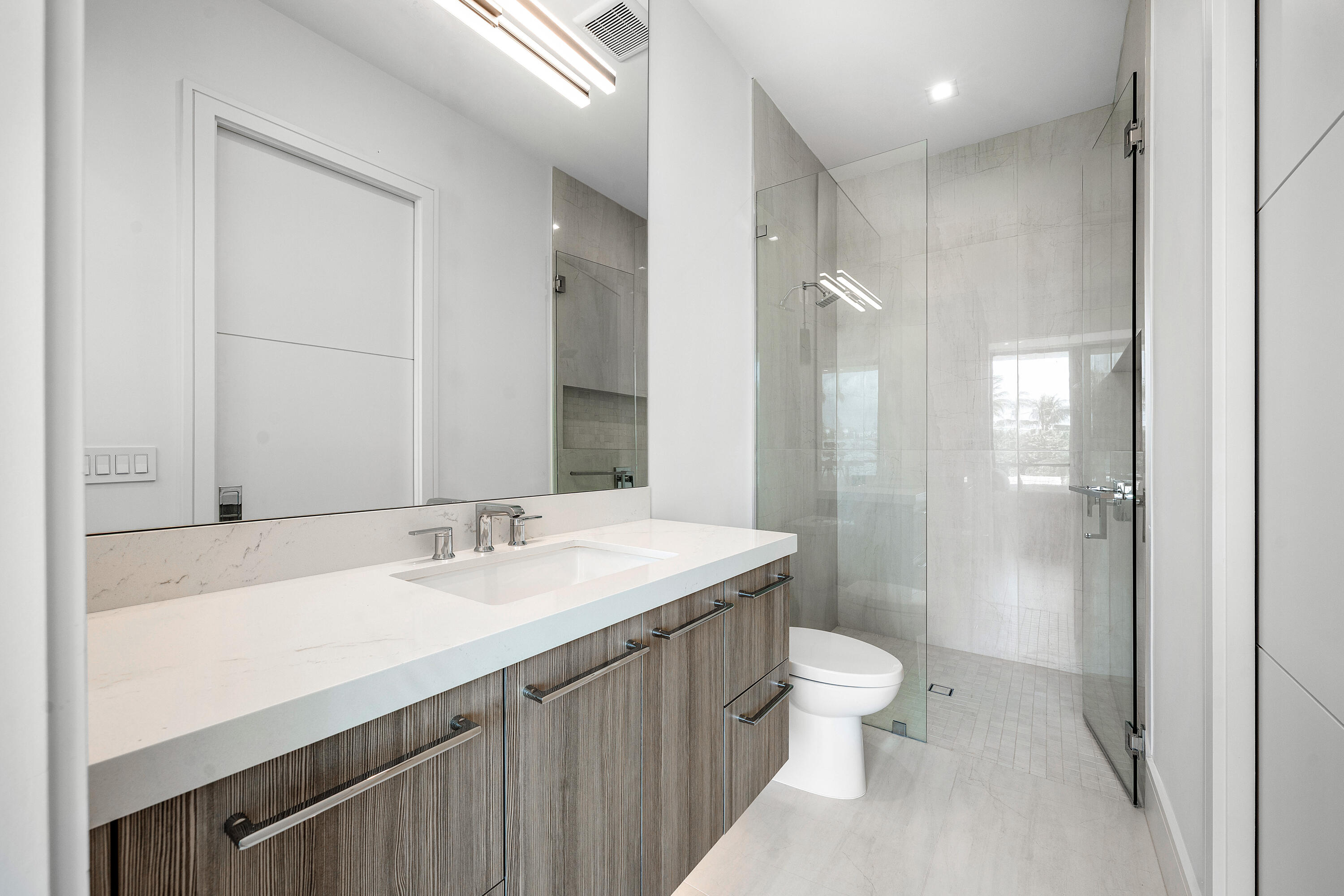 320 Northeast Wavecrest Way Boca Raton, FL 33432 - Photo 50 of 65 a bathroom with a sink a toilet a shower and a mirror
