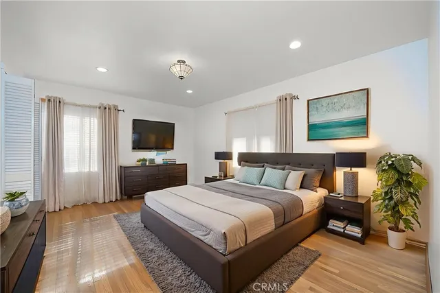 a spacious bedroom with a bed a couch and a flat screen tv