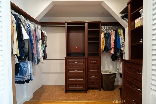 a view of walk in closet with clothes and shoes