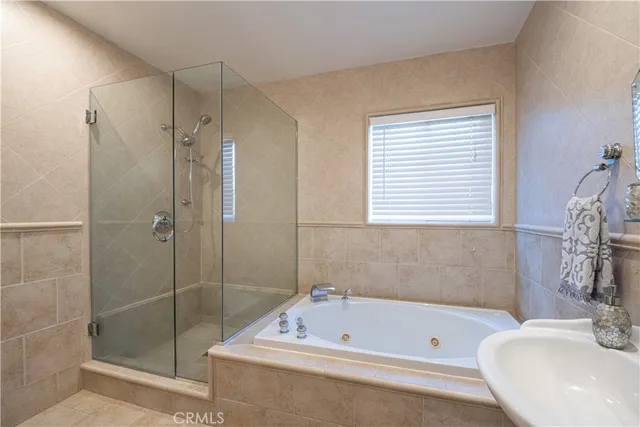 a bathroom with a tub a sink a window and a shower